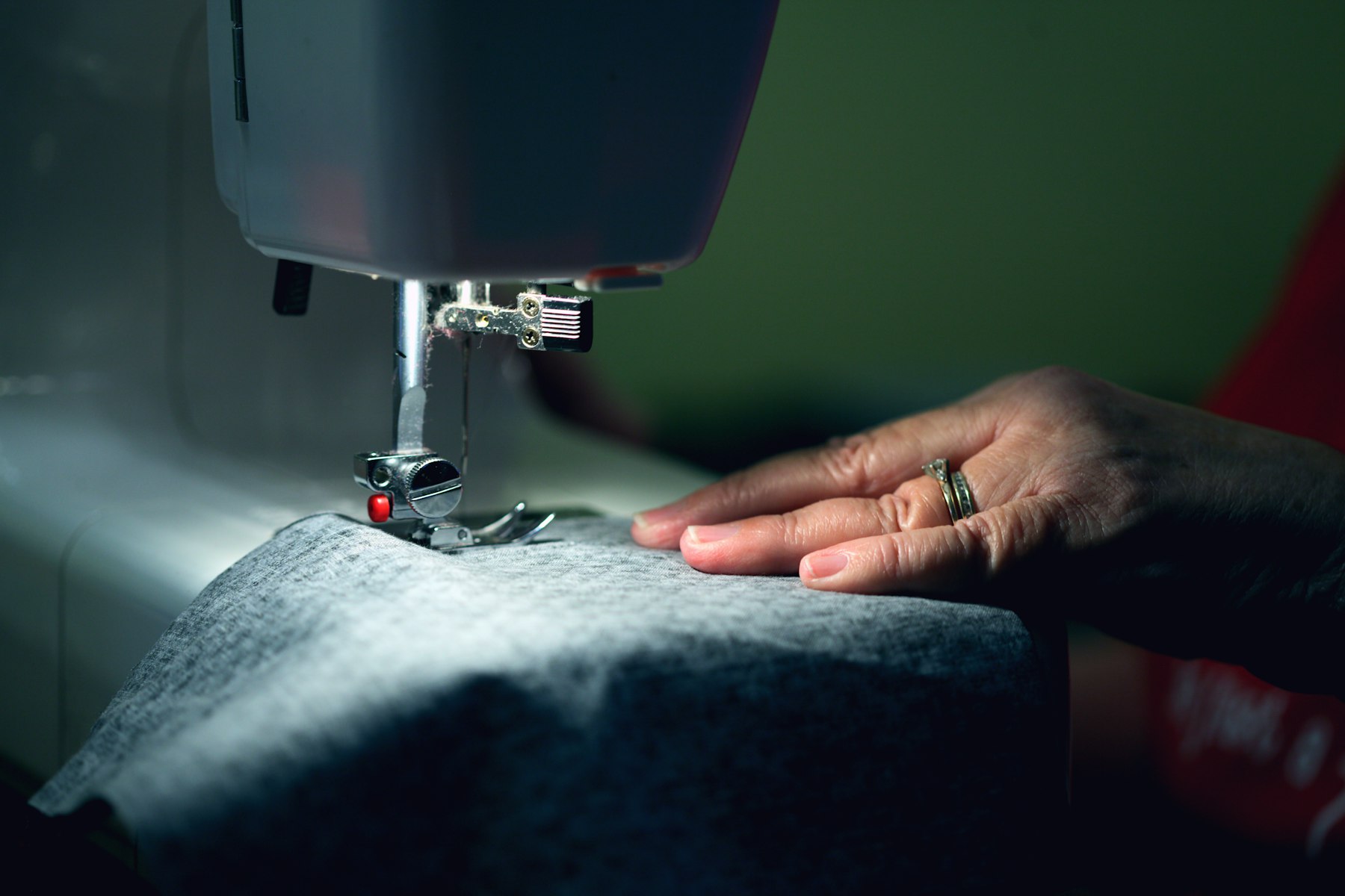 Hands guiding fabric under a sewing machine